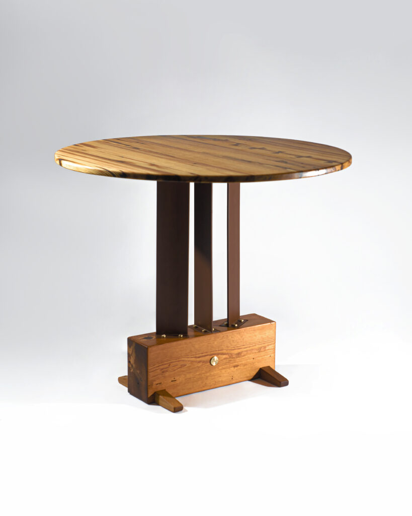 Handcrafted wooden table with metal legs and brass details.